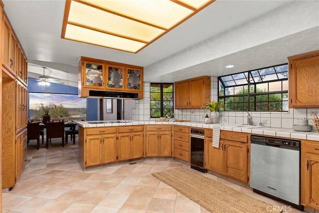 kitchen featuring tasteful backsplash, tile counters, dishwasher, and a healthy amount of sunlight