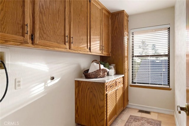 laundry room featuring cabinets and light tile patterned floors