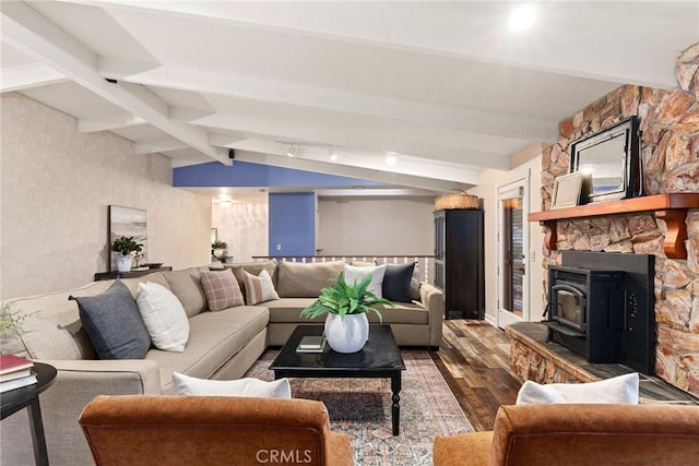 living room with lofted ceiling with beams, hardwood / wood-style flooring, and a wood stove