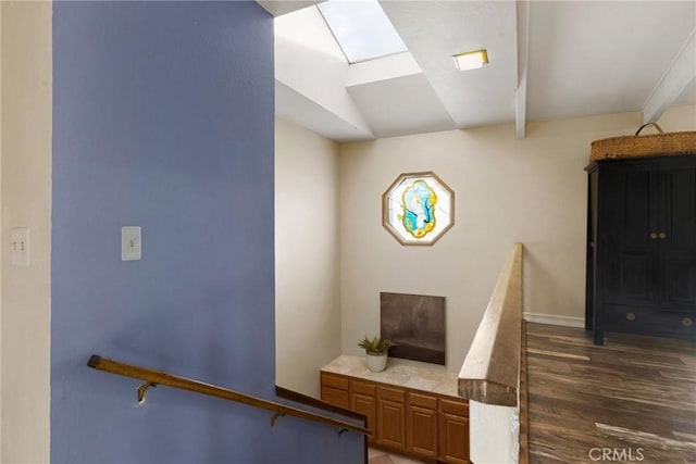 stairs with a skylight and hardwood / wood-style flooring