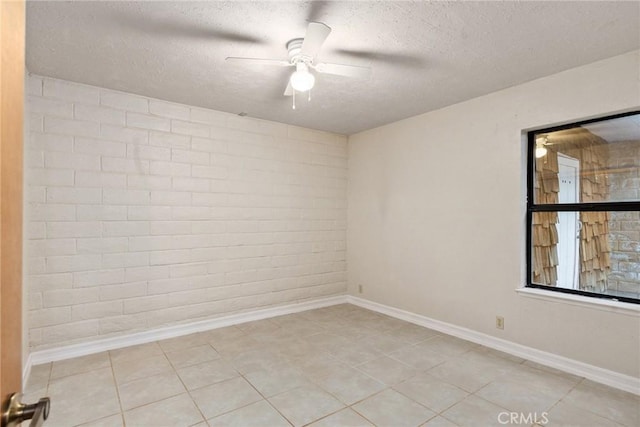 tiled spare room featuring ceiling fan and a textured ceiling