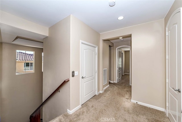 hallway featuring light colored carpet