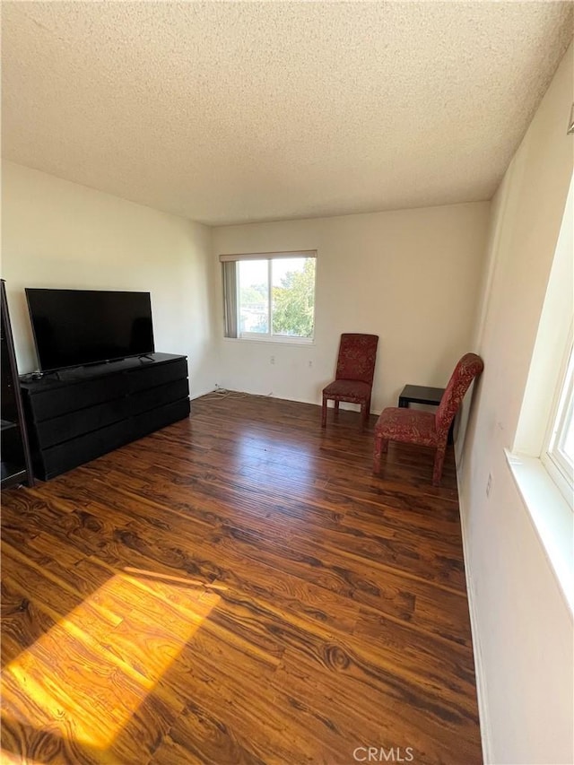 sitting room with dark hardwood / wood-style flooring and a textured ceiling