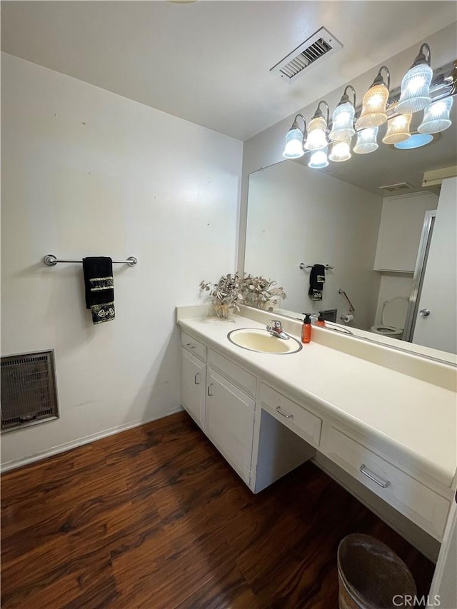 bathroom with vanity, wood-type flooring, and heating unit