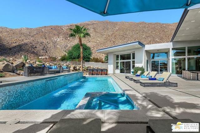 view of pool with a mountain view, an in ground hot tub, and a patio