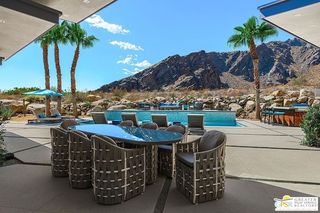 view of patio with a pool and a mountain view