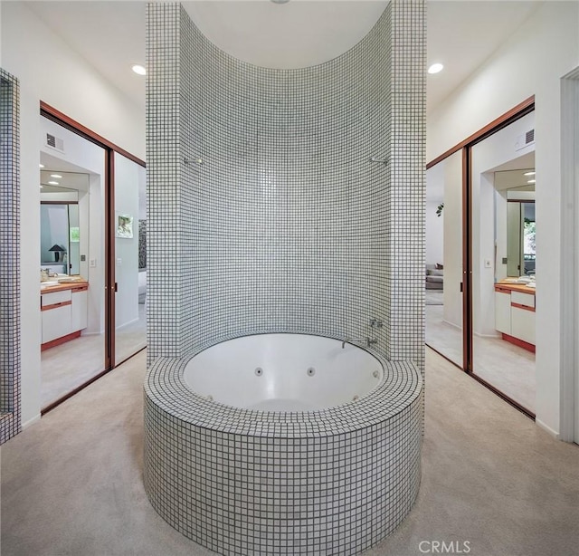 full bathroom featuring recessed lighting, a tub with jets, visible vents, and vanity