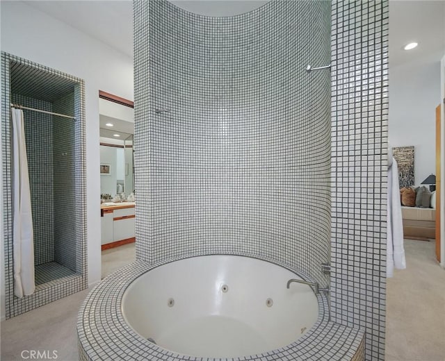 full bath featuring a whirlpool tub, a tile shower, and vanity