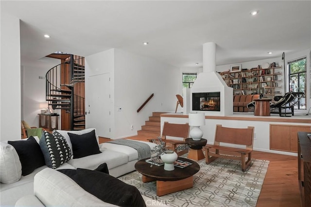 living room with a large fireplace and light hardwood / wood-style flooring