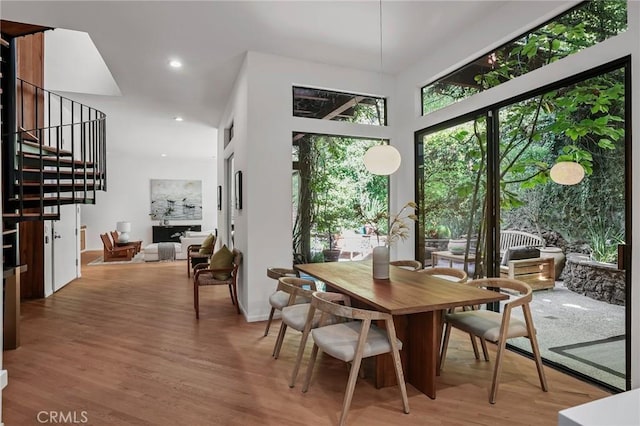 dining room featuring stairs, light wood-type flooring, and recessed lighting