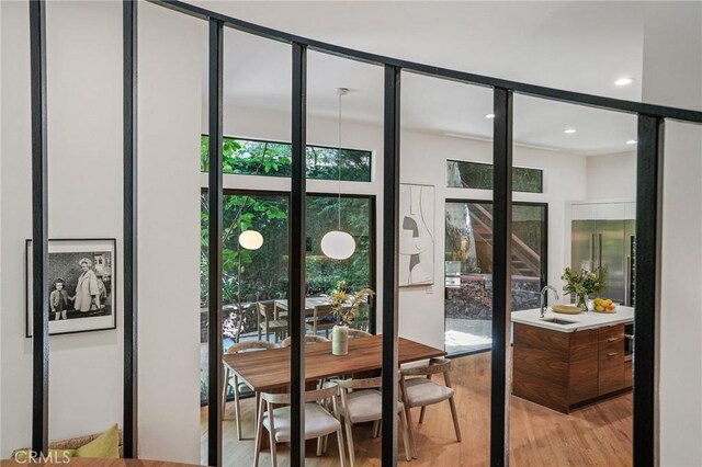 doorway to outside featuring plenty of natural light, light hardwood / wood-style floors, and sink