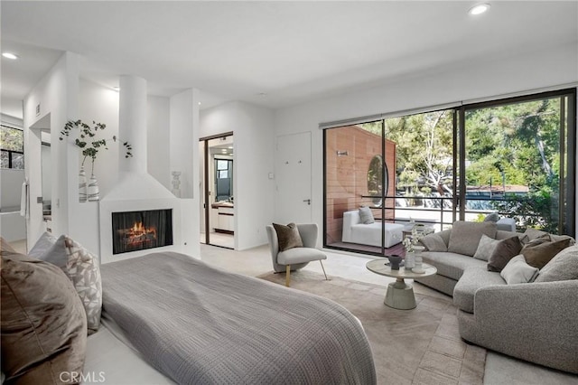 bedroom featuring access to exterior, a lit fireplace, and recessed lighting