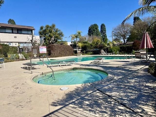 view of swimming pool with a hot tub and a patio area