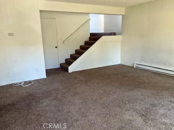 basement featuring a baseboard radiator and dark colored carpet