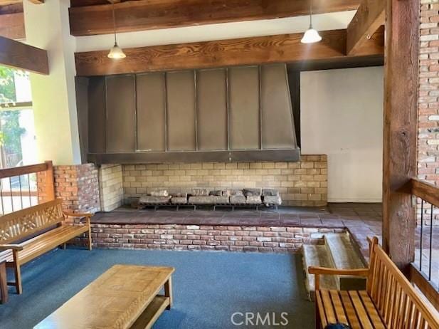 kitchen with decorative light fixtures, beamed ceiling, and dark colored carpet