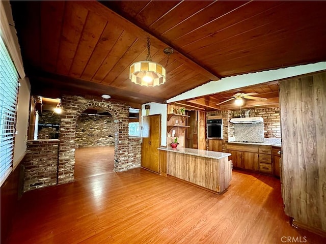 kitchen with vaulted ceiling with beams, light hardwood / wood-style floors, kitchen peninsula, and wooden ceiling