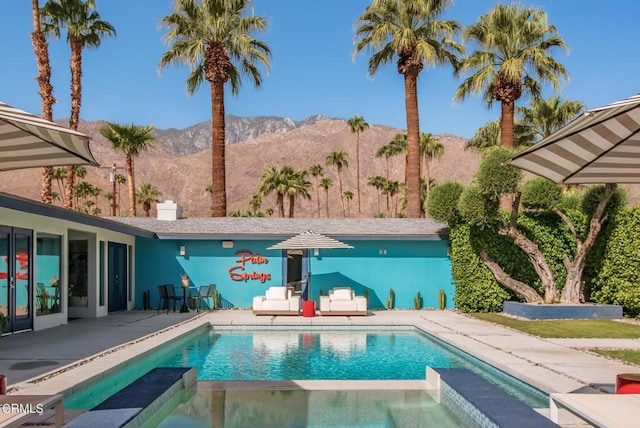 view of pool featuring a mountain view, an in ground hot tub, and a patio area