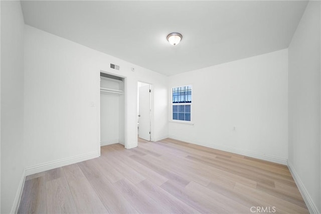 unfurnished bedroom with light hardwood / wood-style floors and a closet