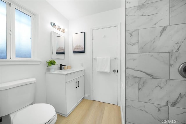 bathroom with hardwood / wood-style floors, vanity, and toilet