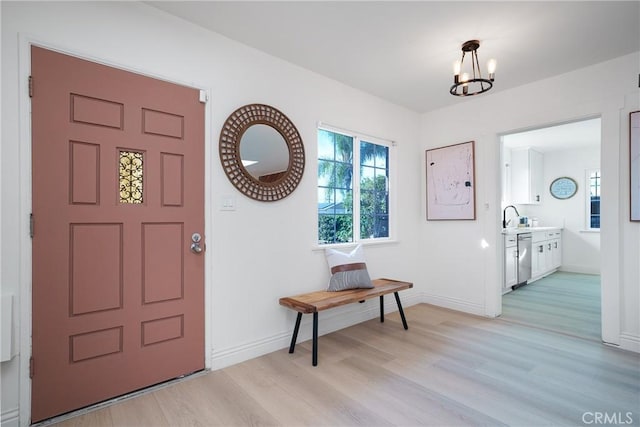 entrance foyer featuring an inviting chandelier and light hardwood / wood-style flooring