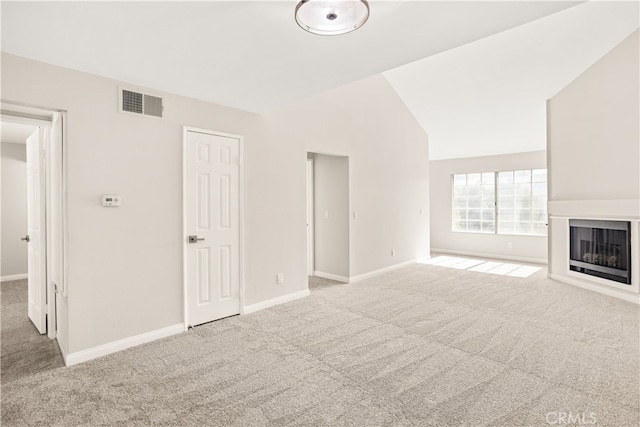 unfurnished living room featuring vaulted ceiling and light carpet