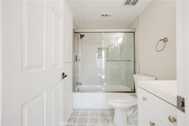 full bathroom featuring vanity, enclosed tub / shower combo, and toilet