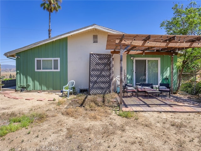 rear view of property with an outdoor living space and a pergola