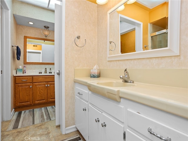 bathroom featuring a shower with door and vanity