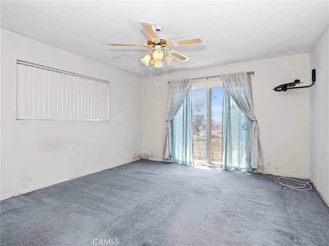 carpeted spare room featuring a textured ceiling and ceiling fan