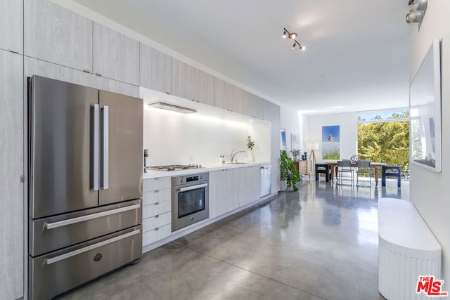 kitchen featuring sink, stainless steel appliances, and range hood