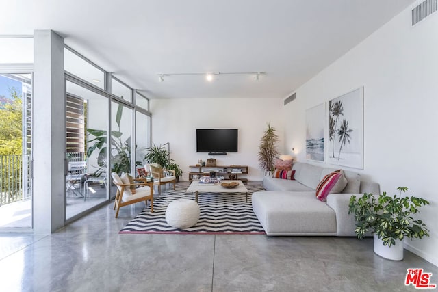 living room with floor to ceiling windows and concrete floors