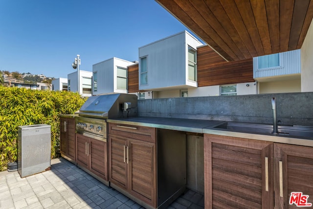 view of patio with grilling area, sink, and an outdoor kitchen