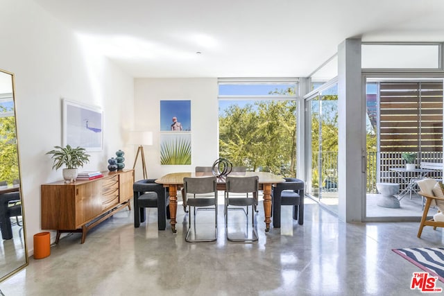 dining space featuring concrete flooring and expansive windows