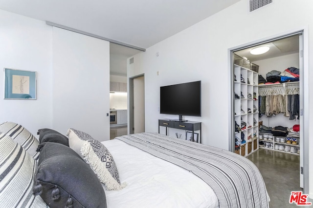 bedroom featuring concrete flooring and a closet