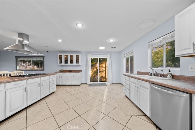 kitchen featuring appliances with stainless steel finishes, a wealth of natural light, extractor fan, sink, and white cabinetry