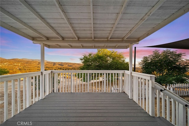 deck at dusk featuring a mountain view