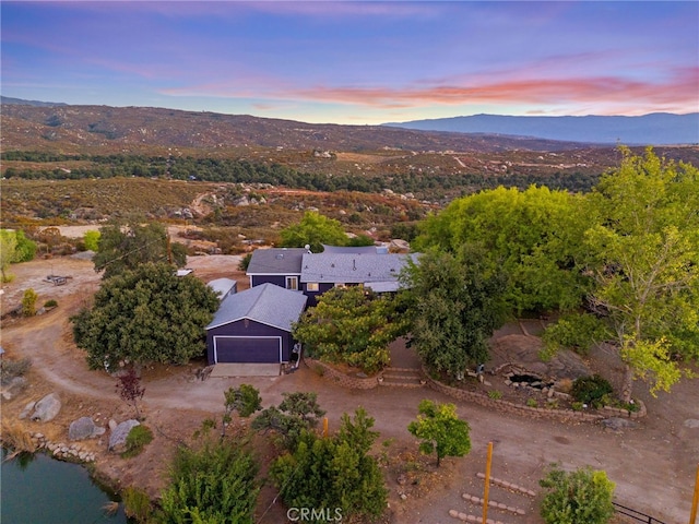 aerial view at dusk featuring a mountain view