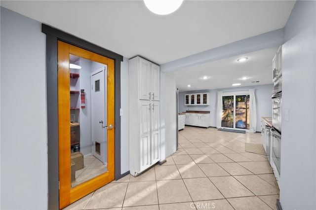 hall with light tile patterned floors