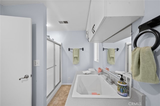 bathroom featuring vanity, tile patterned floors, and walk in shower