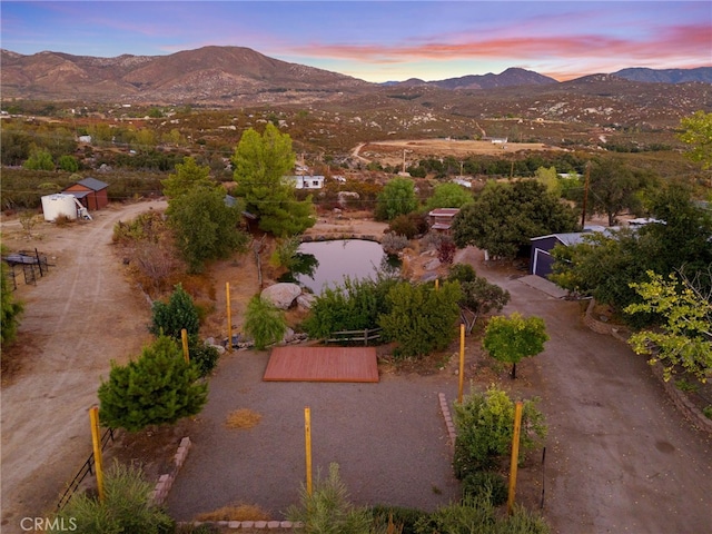 aerial view at dusk featuring a mountain view