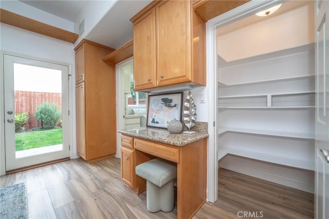 kitchen featuring light stone counters and light hardwood / wood-style flooring