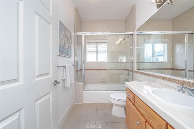 full bathroom featuring tile patterned flooring, vanity, toilet, and shower / bath combination with glass door