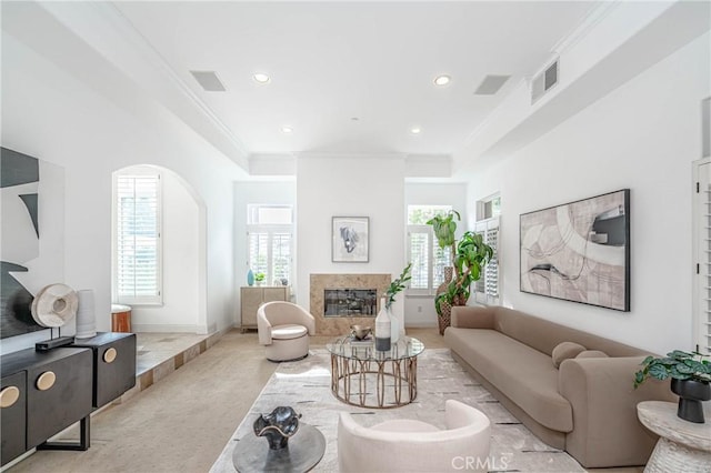 living room featuring crown molding and a high end fireplace