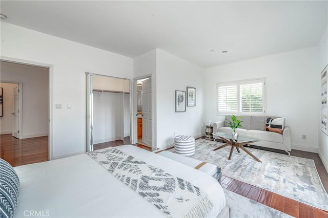 bedroom with a walk in closet, a closet, and hardwood / wood-style floors