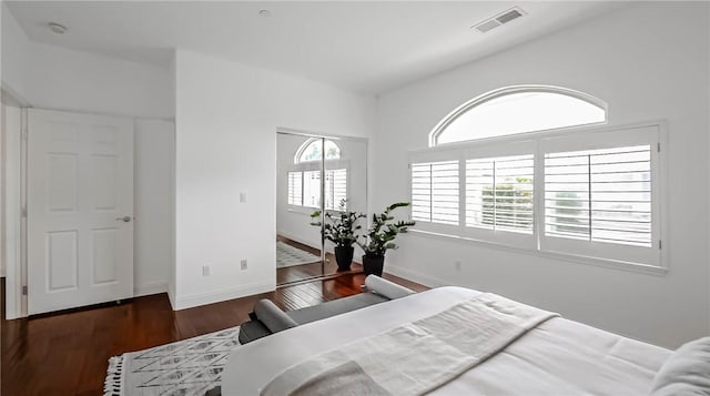 bedroom with dark wood-type flooring and multiple windows