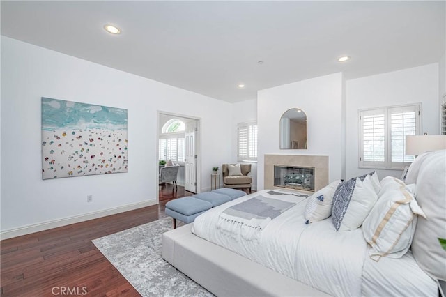 bedroom with a fireplace and dark hardwood / wood-style floors