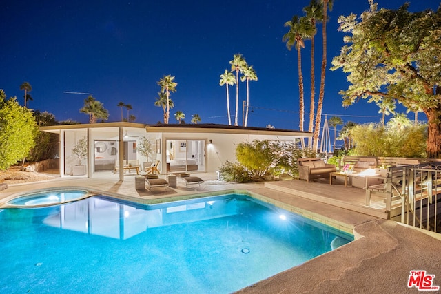 pool at twilight featuring a patio area