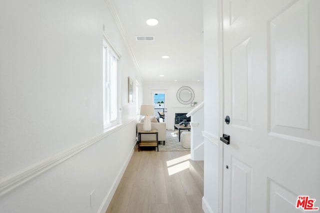 hallway featuring light hardwood / wood-style flooring and ornamental molding