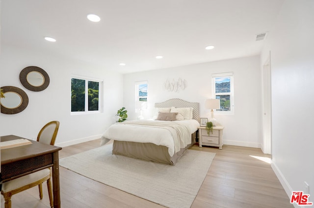 bedroom with light hardwood / wood-style flooring and multiple windows