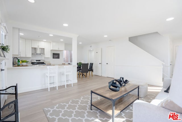 living room with light hardwood / wood-style flooring and sink